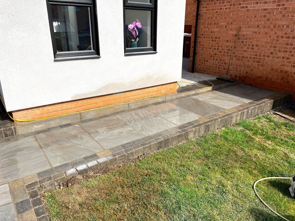 Sandstone step and edging course at the corner of a rendered house