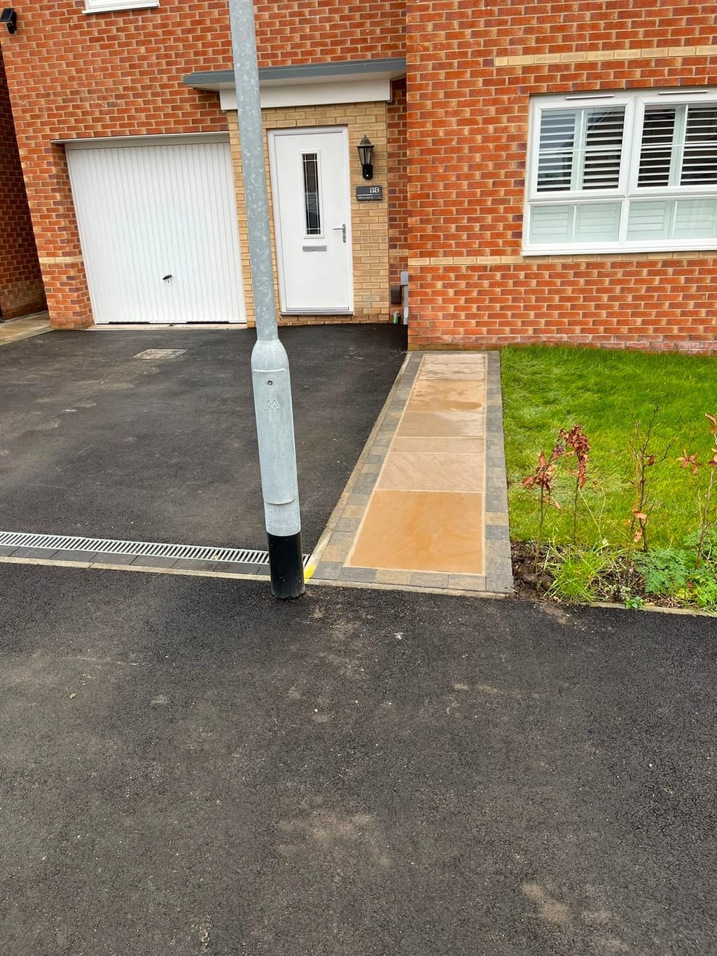Sandstone front path with a sett border laid beside a new tarmac drive and a lawn